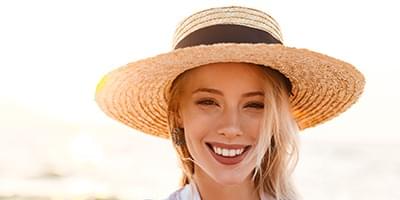 Woman smiling in the sun with straw hat