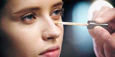 Woman putting concealer on